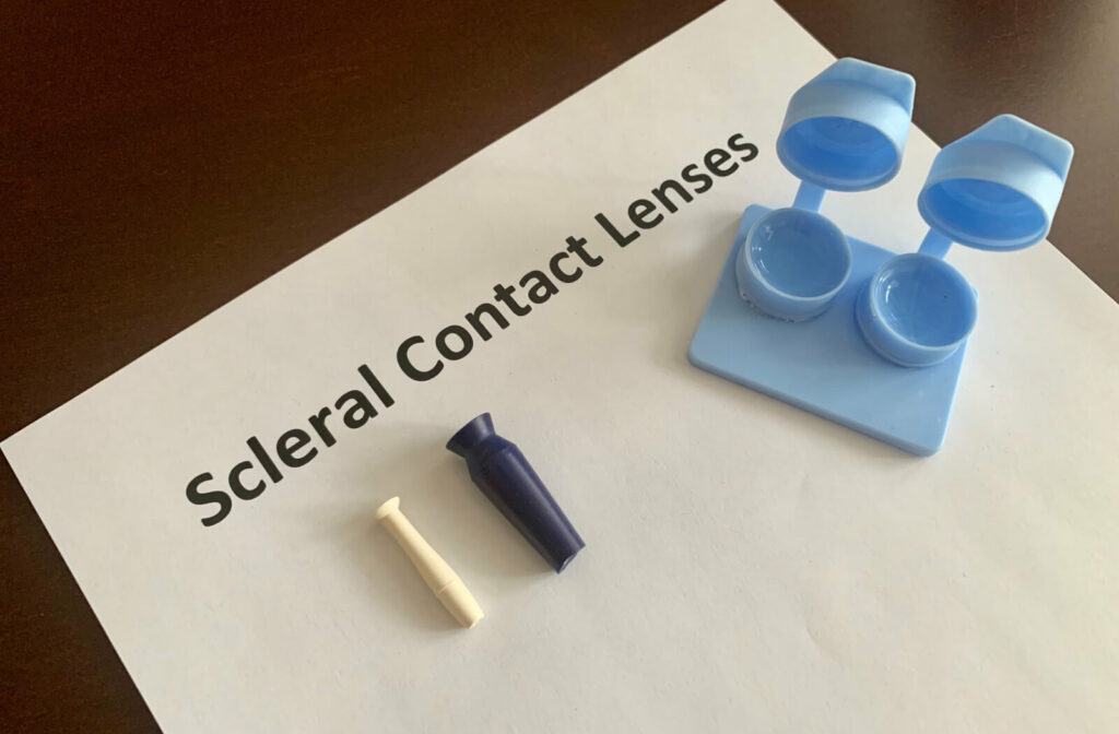 A contact lens case with scleral contacts and a contact lens insertion and removal kit  on the table.